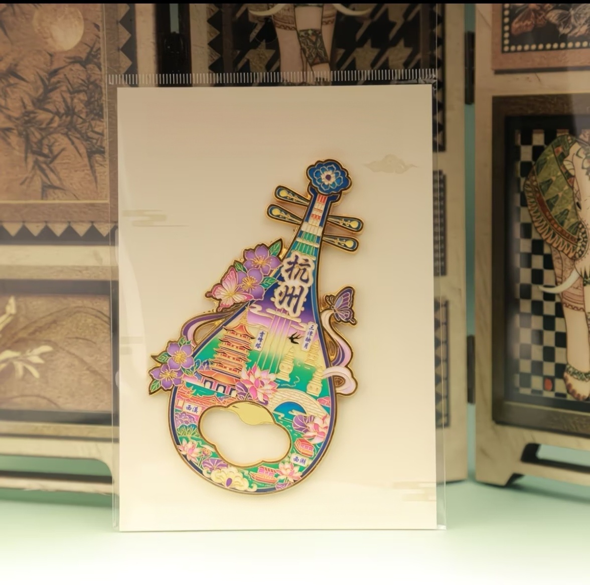 Alloy pipa shaped 2‑in‑1 bottle opener and fridge magnet, purple‑tone Chinese‑style souvenir with Hangzhou West Lake landmarks