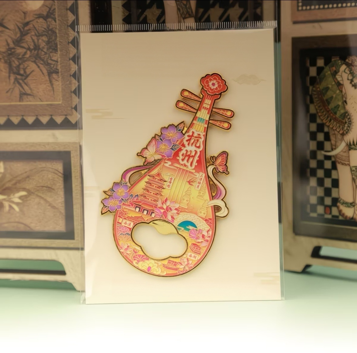 Pipa shaped 2‑in‑1 bottle opener and fridge magnet, warm red‑orange tone Chinese‑style souvenir with Hangzhou West Lake landmarks